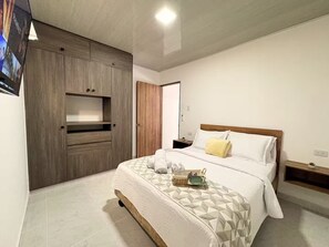 A bedroom with a bed, a wardrobe, a bedside table, and a nightstand. - Apartamento central 5G/AC - Balcon privado (Cali)
