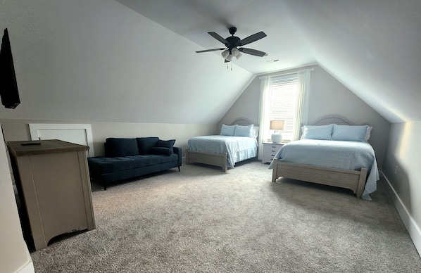 A bedroom with two beds, a ceiling fan, a window with blinds, and a dark-colored sofa. - Woodland Retreat Minutes from Historic Bell Buckle Square (Bell Buckle)