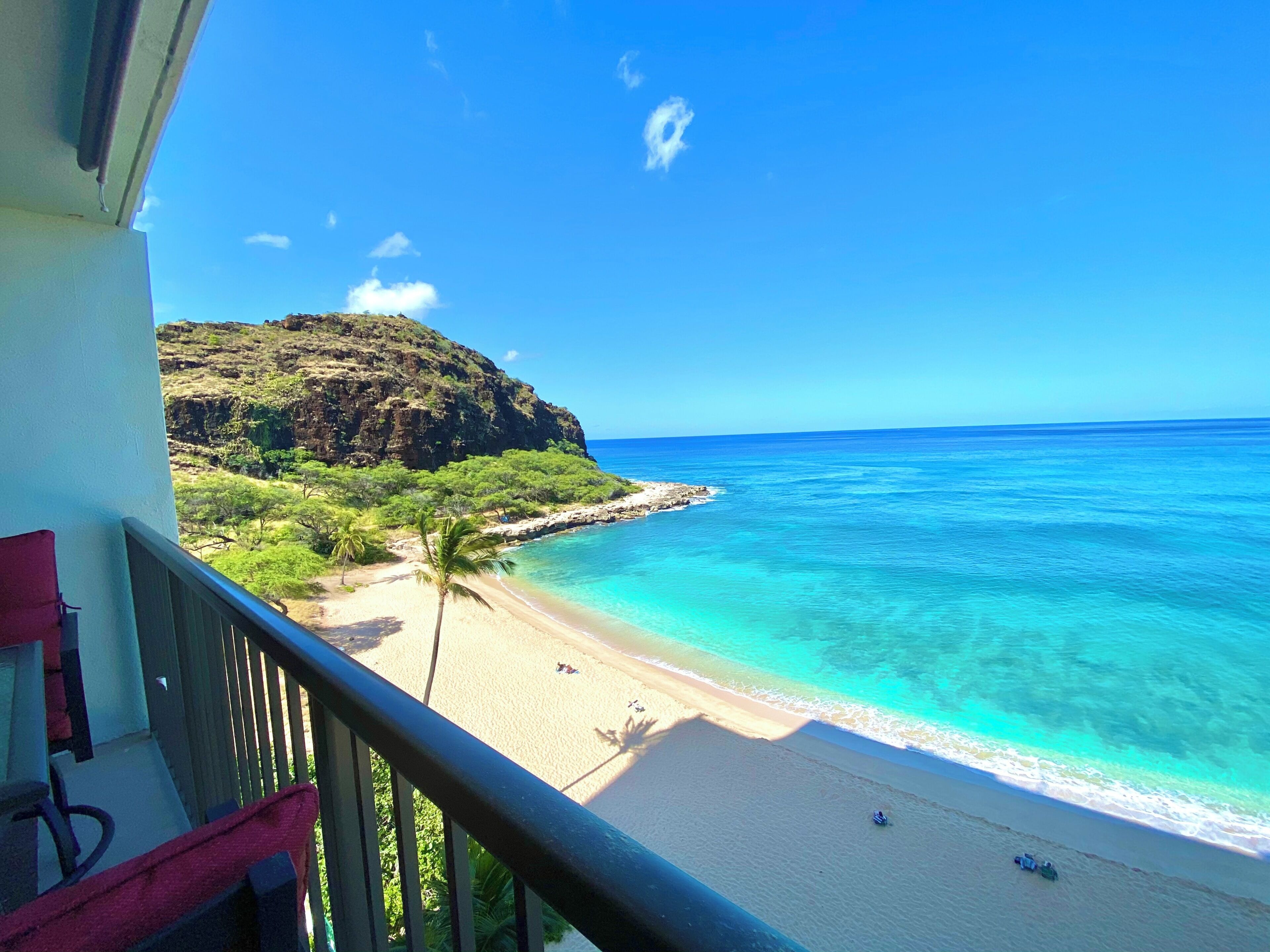 A balcony with a view of a beach and ocean.