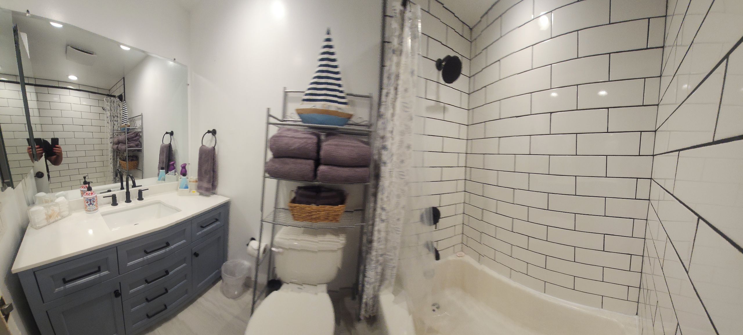 A modern bathroom with a white sink, vanity, and bathtub.
