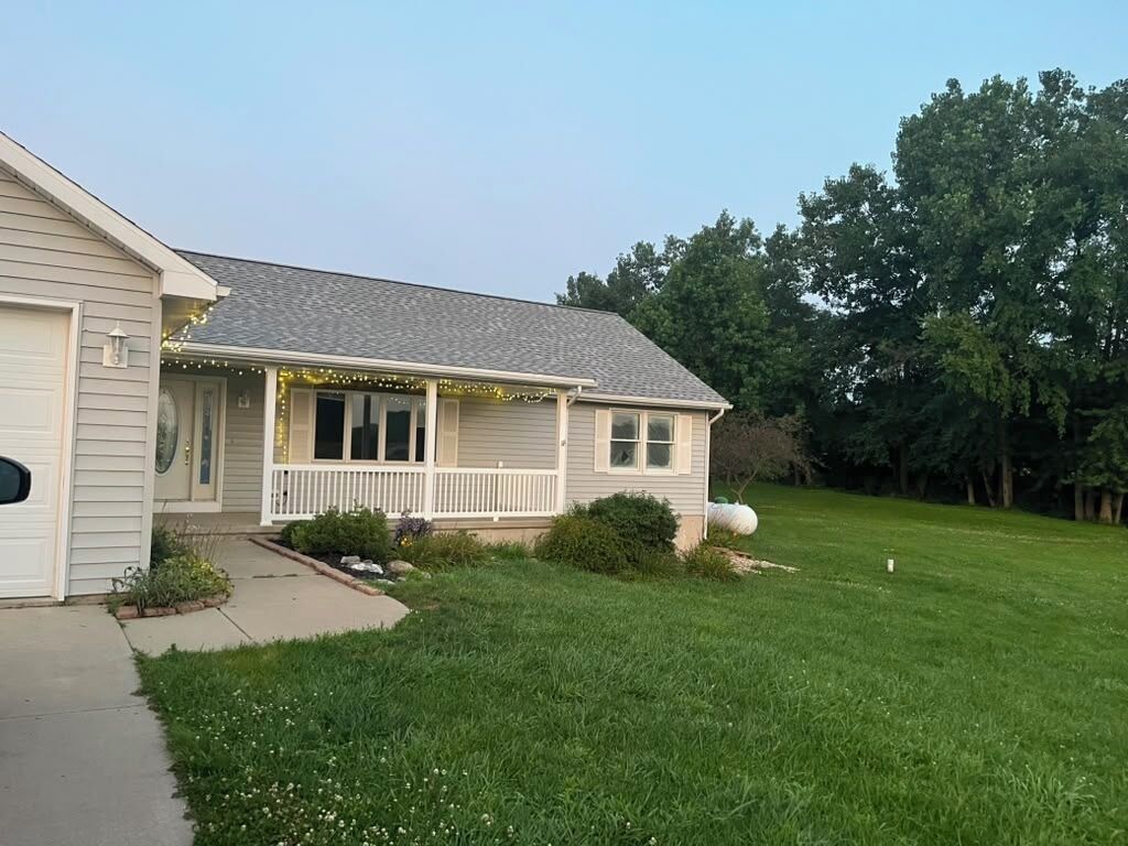 A single-story house with a front porch, a garage, and a well-maintained lawn.