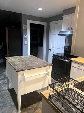 A compact kitchen with a built-in oven, a small countertop, and a dishwasher.