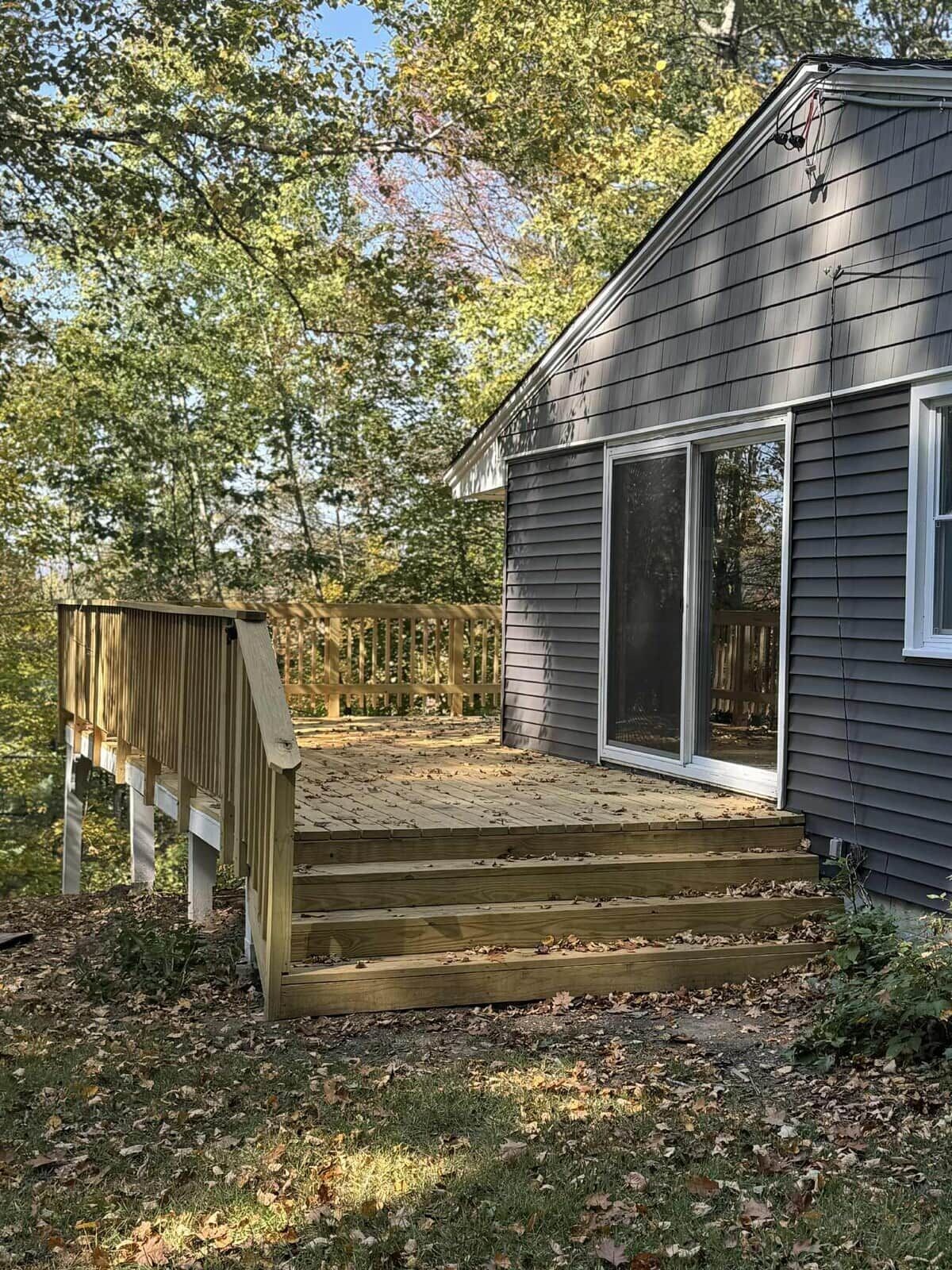 Il s’agit d’une propriété résidentielle dotée d’une terrasse en bois, d’une porte-fenêtre coulissante et d’une cour clôturée.