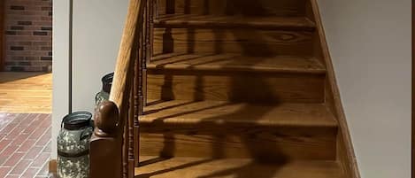A wooden staircase with a handrail and a wall-mounted picture.