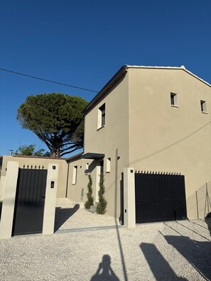 A modern building with a beige facade, a gated entrance, and a tree in the background. - The new, private Villa Bern, just 10 minutes from Avignon🌻 (Sorgues)