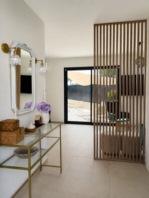 A modern interior with a glass console table, a large mirror, and a wooden partition. - The new, private Villa Bern, just 10 minutes from Avignon🌻 (Sorgues)