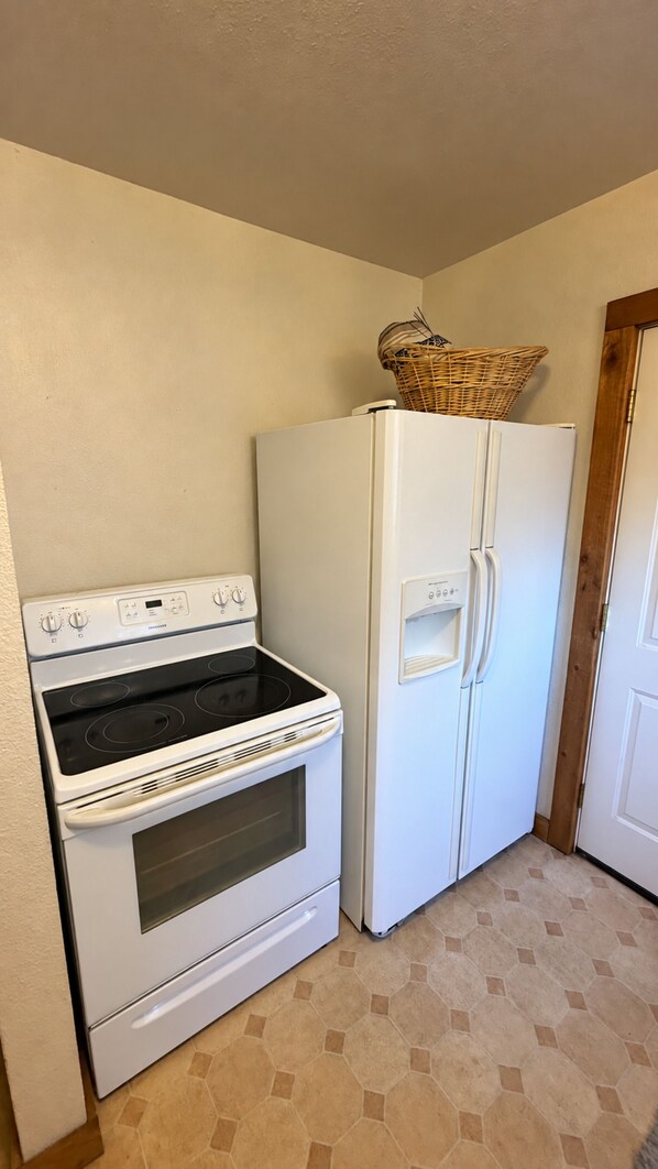 A kitchen with a stove, oven, and refrigerator.