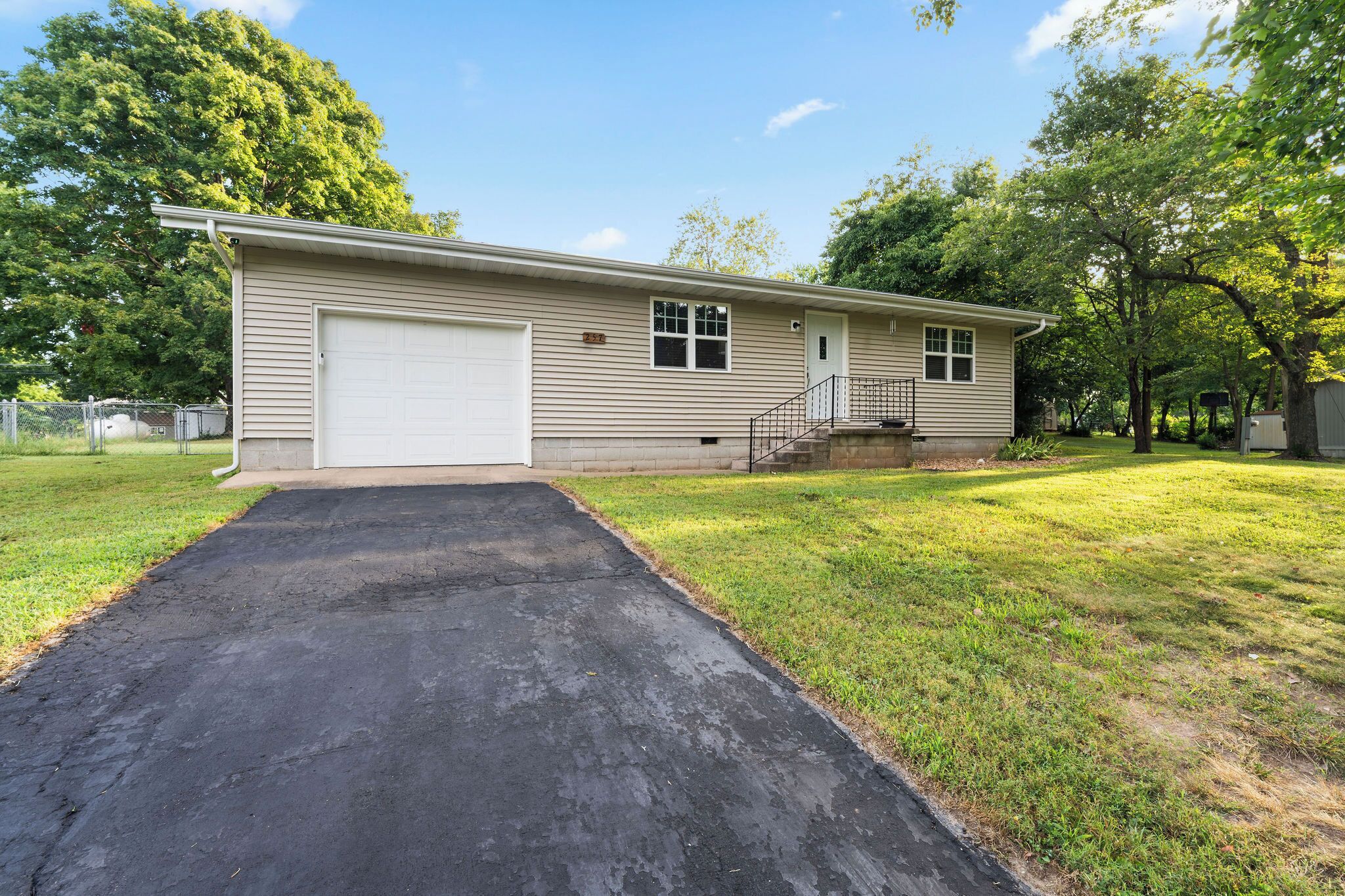 A single-story house with a garage, a front yard, and a driveway.