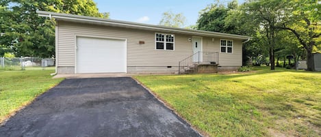 A single-story house with a garage, a front yard, and a driveway.