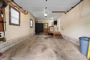A garage with a concrete floor, wooden door, and a washing machine. - Traveling professionals ideal space in Ozark (Ozark)