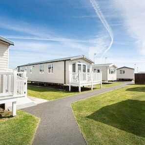 A row of mobile homes with a paved walkway in between. - Cala Gran Holiday Park - Holiday Accommodation 20111 (Fleetwood)