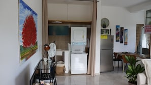 Un espacio habitable compacto con kitchenette, zona de comedor y pequeña sala de estar.