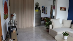 A living room with a sofa, a coffee table, a TV, and a dining area with chairs and a table. - CasaMIA RD: Your Caribbean retreat. (Río San Juan)