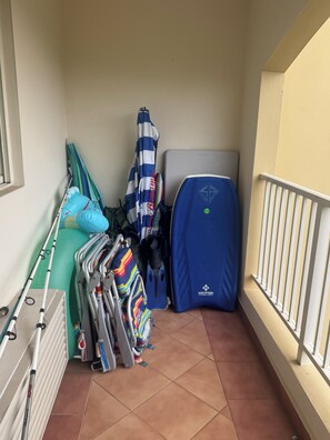 A small balcony with a radiator, a blue folding chair, a blue umbrella, and a blue tent. - Luxury Aguadilla Penthouse Ocean & Sunset Views 3BR (Aguadilla)