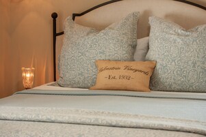 Una cama con almohadas estampadas y una etiqueta que indica el año de fundación.