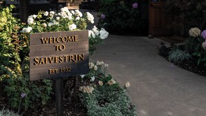 A wooden sign with 'WELCOME TO SALVESTRIN' and 'EST. 1932' indicating the establishment year.