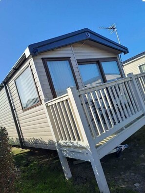 A mobile home with a balcony, a satellite dish, and a visible garage door. - Cala Gran Holiday Park - Holiday Accommodation 20084 (Fleetwood)