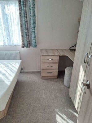 A bedroom with a bed, a desk, and a wardrobe. - Cala Gran Holiday Park - Holiday Accommodation 20084 (Fleetwood)