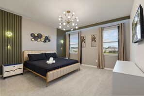 Ein Schlafzimmer mit Bett, Nachttisch, Wandbild und Fernseher.