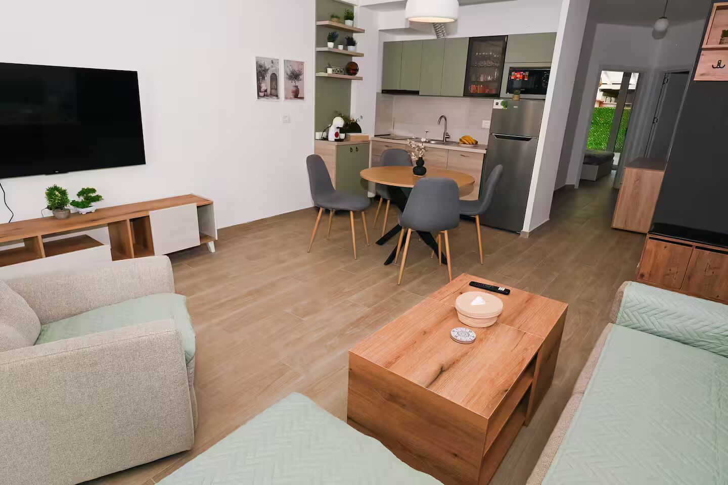 A modern living room with a sofa, a coffee table, and a TV.