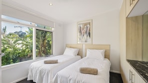 A hotel room with two beds, a large window, a painting, and a wooden cabinet. - PI Holiday Retreat Unit 3 (Cowes)