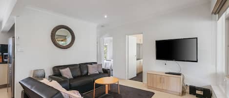 Una sala de estar moderna con un sofá, una mesa de centro y un televisor de pantalla plana.