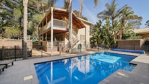 A two-story building with a balcony, a swimming pool, and surrounding palm trees. - PI Holiday Retreat Unit 3 (Cowes)