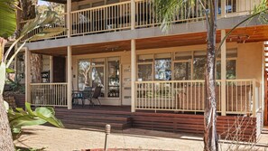 A two-story building with a balcony, wooden deck, and outdoor seating area. - Unit 2 PI Holiday Retreat (Cowes)