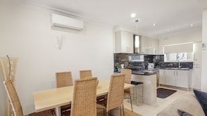 A modern kitchen with a marble countertop, white cabinets, and a built-in oven. - PI Holiday Retreat in Chapel Street (Cowes)