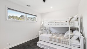 A bunk bed room with a window, white walls, and a ceiling light. - Home and Away in Cowes (Cowes)