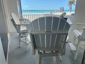 A beachside patio with Adirondack chairs and a view of the ocean. - Condo Right on the Beach, 2-bedroom lovely Redington, Pool, Patio, Gulf Views (Redington Beach)