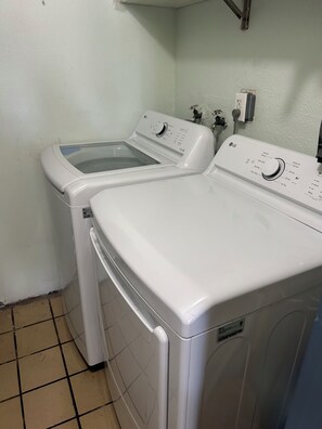 A laundry room with two front-loading washing machines and a dryer. - Condo Right on the Beach, 2-bedroom lovely Redington, Pool, Patio, Gulf Views (Redington Beach)