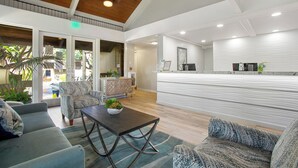 Un'area reception moderna con soffitto in legno, una scrivania e posti a sedere.
