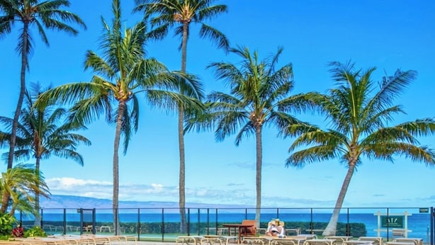 A pool area with palm trees and a view of the ocean. - 2 Villas, Oceanfront, 3 Bedrooms, Sleeps 6 (Kaanapali)