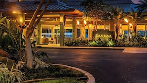 A hotel entrance with a sign reading 'MAHANA,' surrounded by tropical plants and palm trees. - 2 Villas, Oceanfront, 3 Bedrooms, Sleeps 6 (Kaanapali)