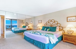 Habitación de hotel con dos camas, un balcón con vistas y un espejo grande.
