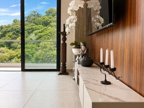 Un intérieur moderne avec un comptoir en marbre, une plante en pot, un vase et des bougies.