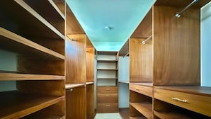 Un vestidor amplio con varios estantes y cajones de madera.