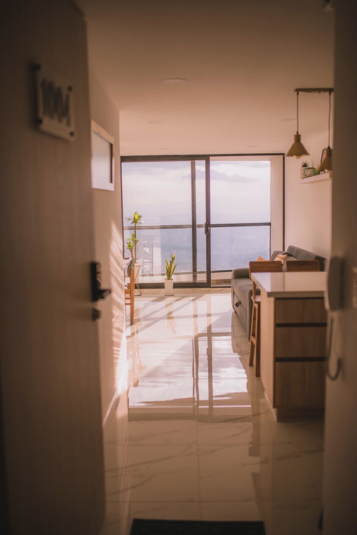 Una cocina moderna con un ventanal grande, un sofá y una zona de comedor.