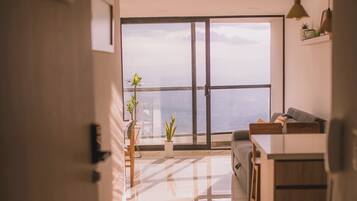 Una cocina moderna con un ventanal grande, un sofá y una zona de comedor.
