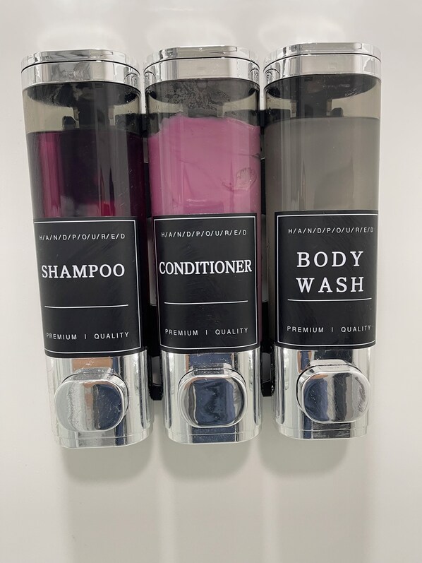 Three bottles of personal care products labeled shampoo, conditioner, and body wash.