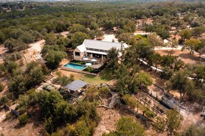 A large house with a swimming pool, surrounded by trees and a hilly landscape. - Private 14 Acre Estate on Barton Creek with Two Homes, Pool and Multiple Gardens (Austin)