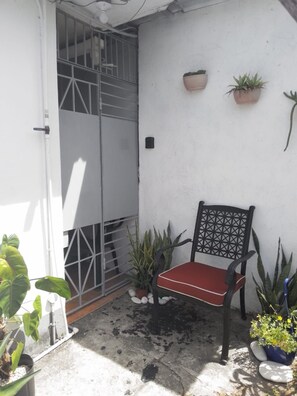 A small outdoor seating area with a chair and potted plants.