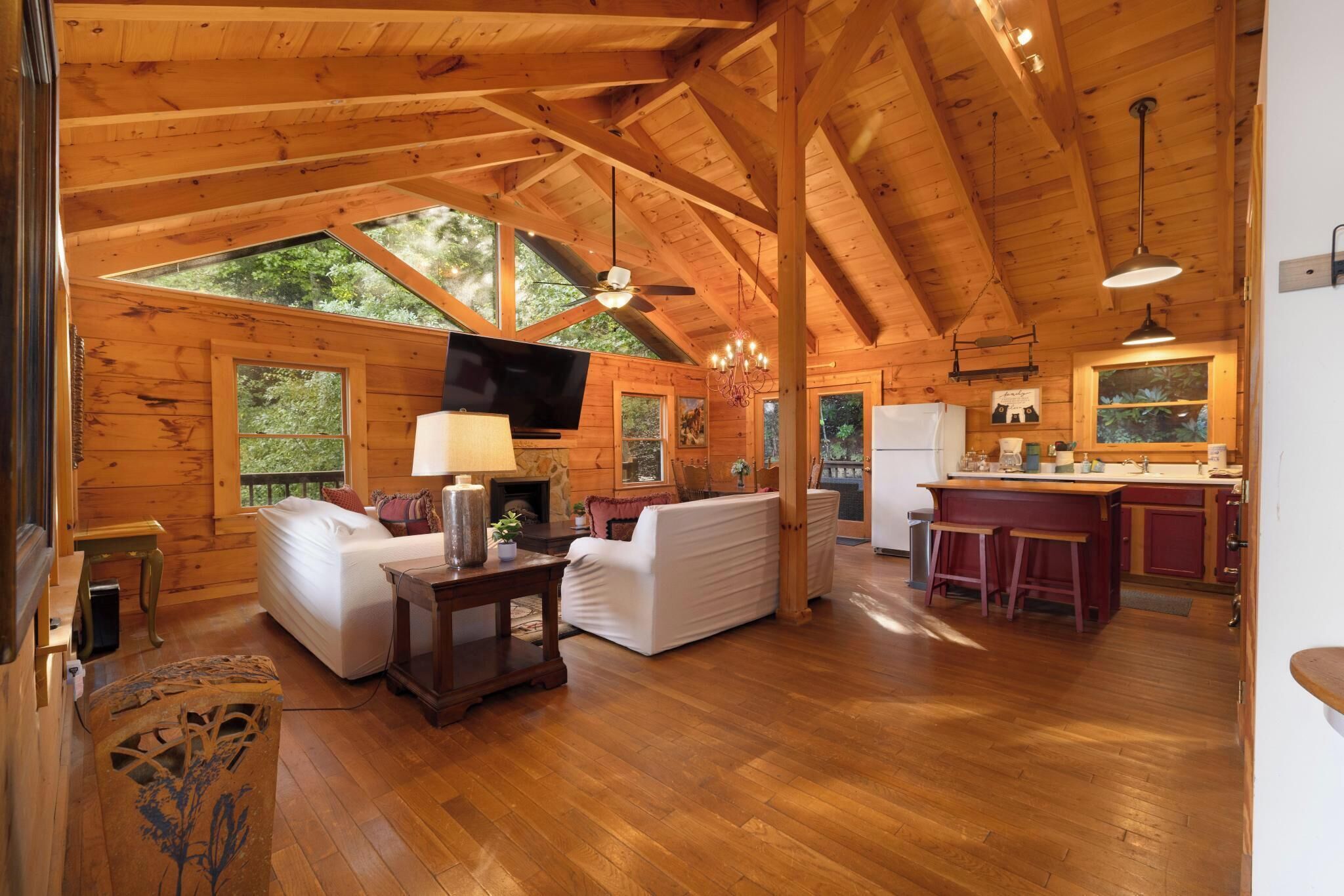 A spacious wooden cabin with a living area, a kitchen, and a dining area.