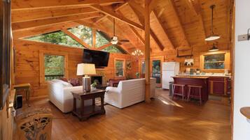 A spacious wooden cabin with a living area, a kitchen, and a dining area.