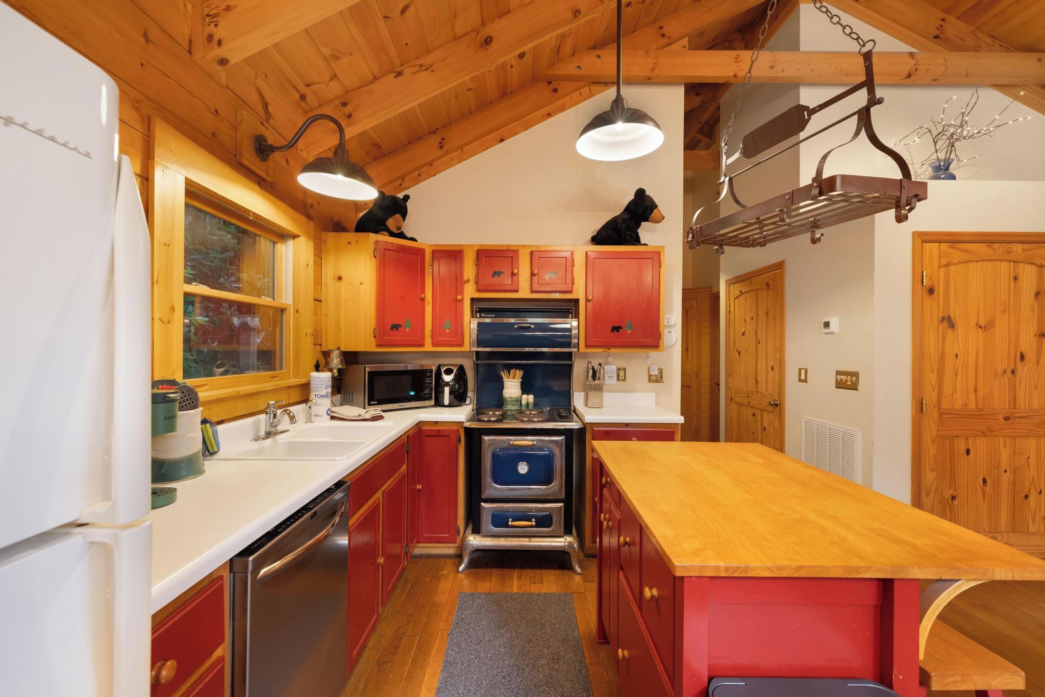 Une cuisine avec des meubles de rangement en bois, une cuisinière et un réfrigérateur.