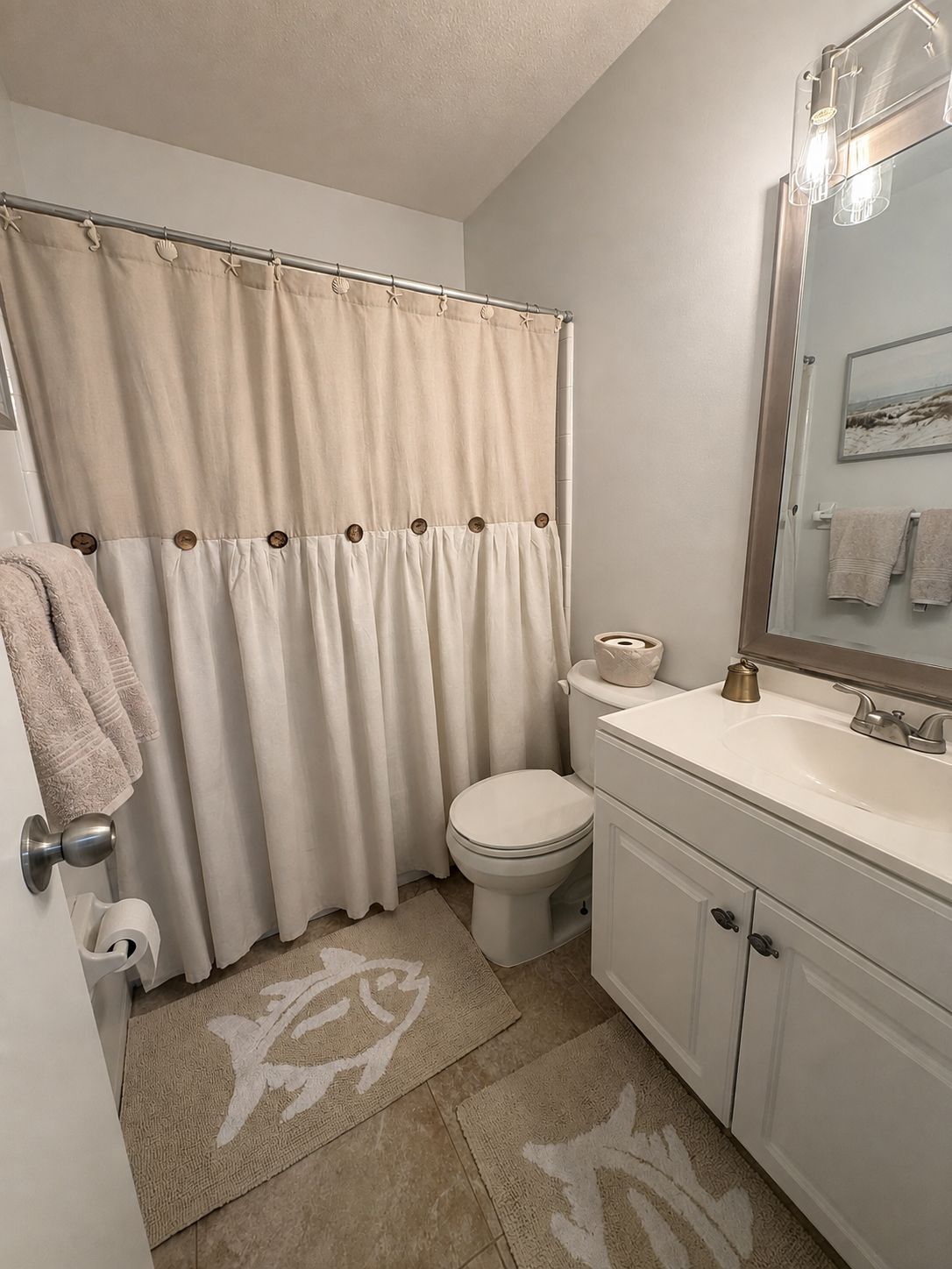 A bathroom with a toilet, sink, and shower curtain.