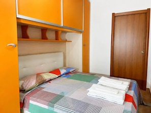 A bedroom with a bed, a wardrobe, and a door. - Grande spazio esterno con idromassaggio (Valledoria)