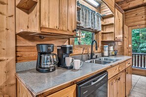A wooden cabin kitchen with a coffee maker, a sink, and a dishwasher. - Free Dollywood Tix/Theater/Pool Table/Spacious (Sevierville)
