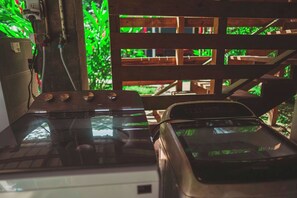 Een kamer met een houten trap, een tafel met een glazen blad en een auto die erin geparkeerd staat.